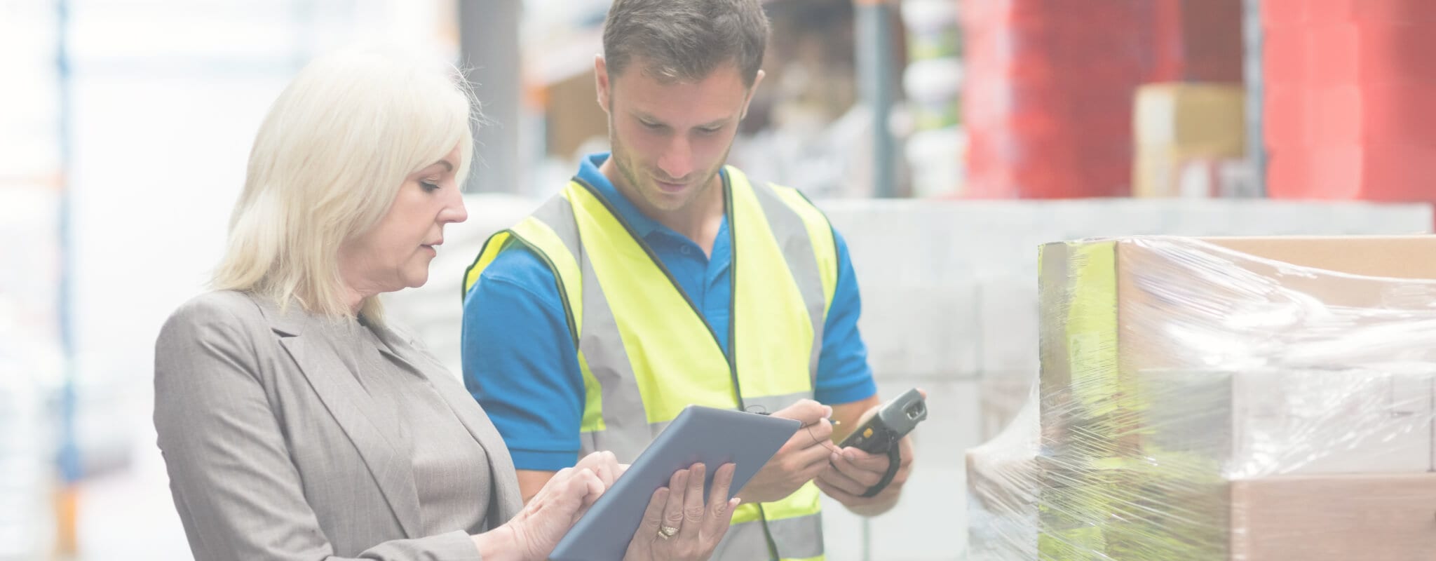 Manager using tablet while worker scanning package